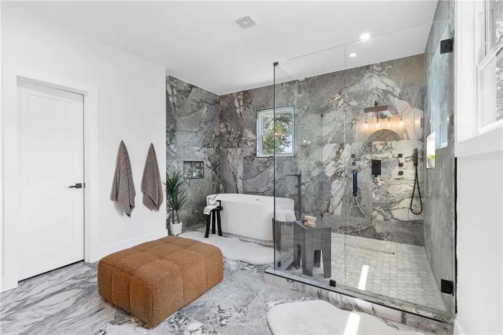 Full bath featuring a soaking tub, marble finish flooring, a marble finish shower, and recessed lighting