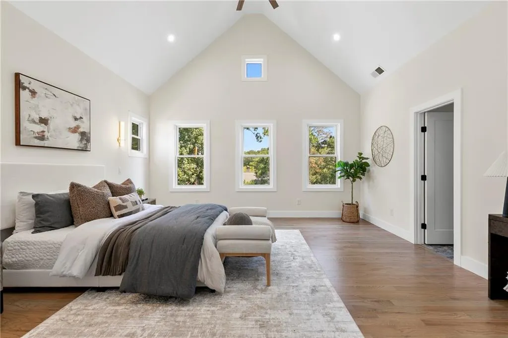 Bedroom with high vaulted ceiling, light wood-style flooring, ceiling fan, and recessed lighting