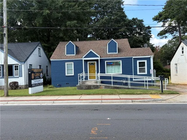 Blue exterior with white trim, a brown shingle roof, and a bright yellow door