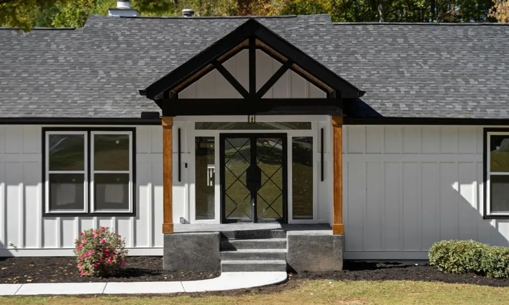 Property entrance with roof with shingles and board and batten siding