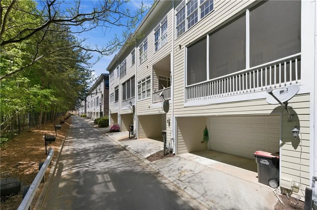 View of property exterior featuring a garage, concrete driveway, and a balcony