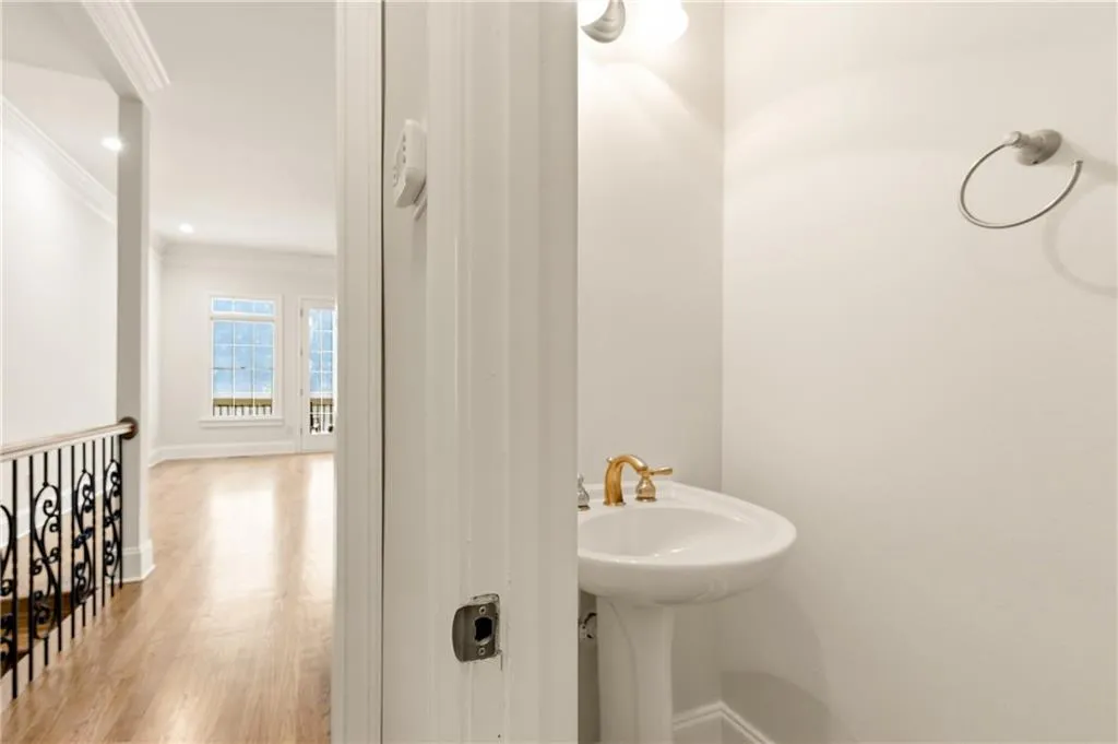 Bathroom with wood finished floors, crown molding, and recessed lighting