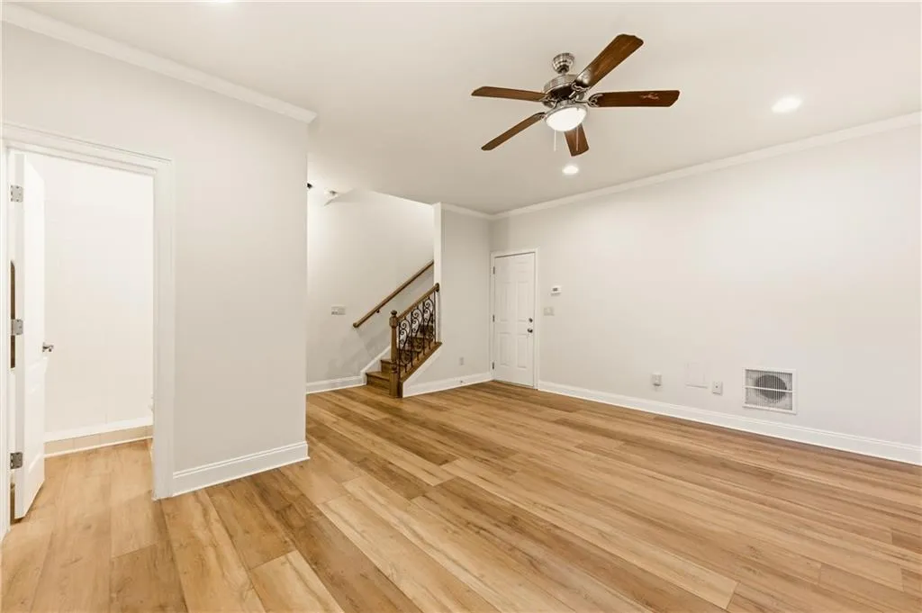 Unfurnished living room featuring light wood-style flooring, crown molding, ceiling fan, and recessed lighting