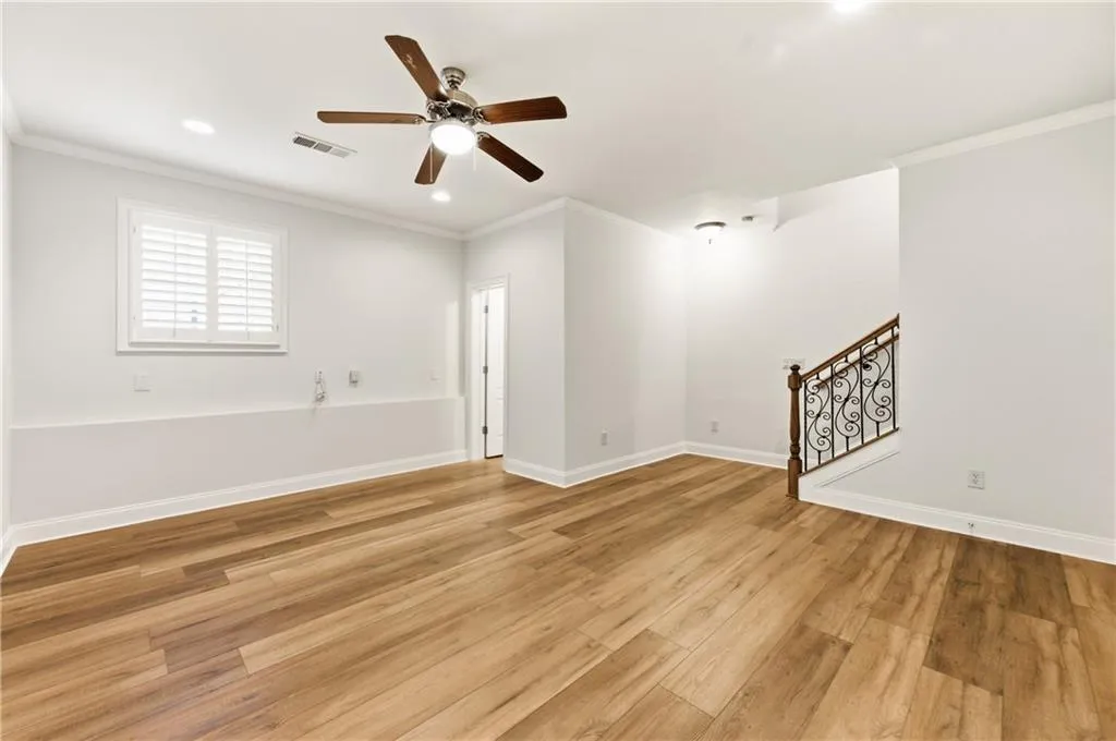 Empty room featuring crown molding, a ceiling fan, light wood-style flooring, and recessed lighting