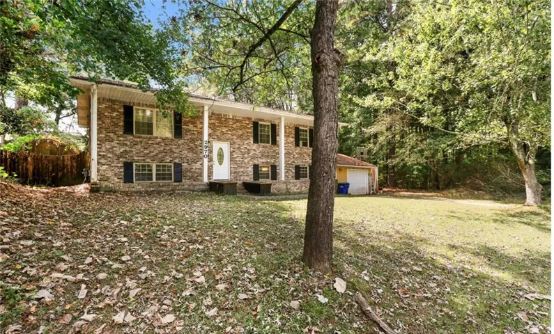 Bi-level home featuring brick siding, a garage, and a front yard