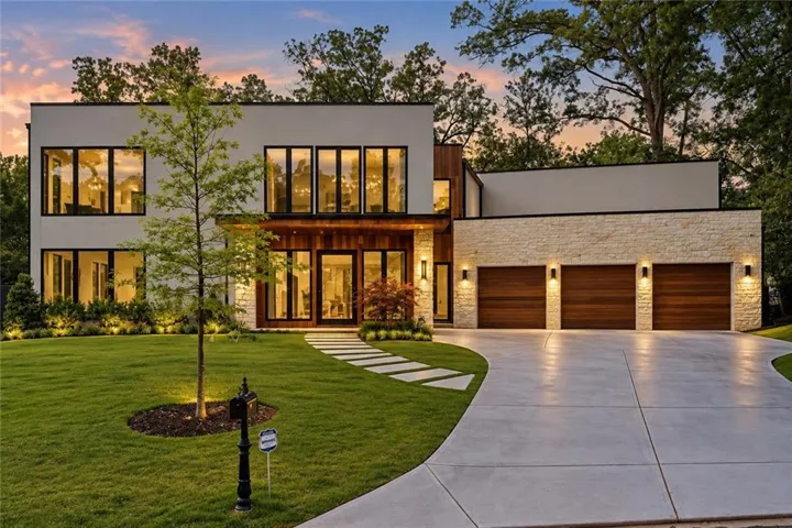 Modern architectural design with expansive windows and a manicured lawn
