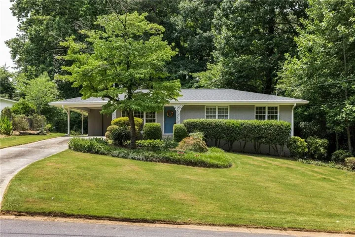 Ranch-style residence featuring a gray exterior with white trim, a dark gray roof, and a blue front door