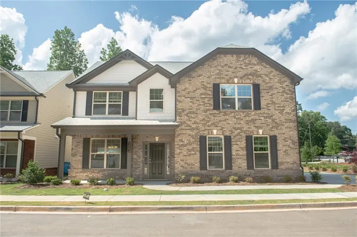 Brick and siding exterior with a covered front entrance and dark shutters