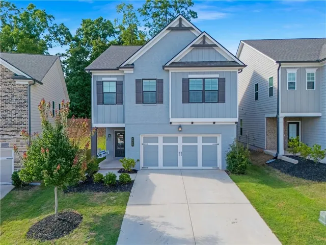 Two-story residence featuring a two-car garage, durable hardiplank siding, a covered front entry, and concrete driveway