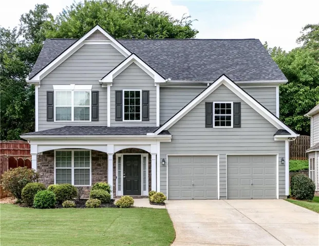 Contemporary two-story residence featuring grey siding and dark shutters