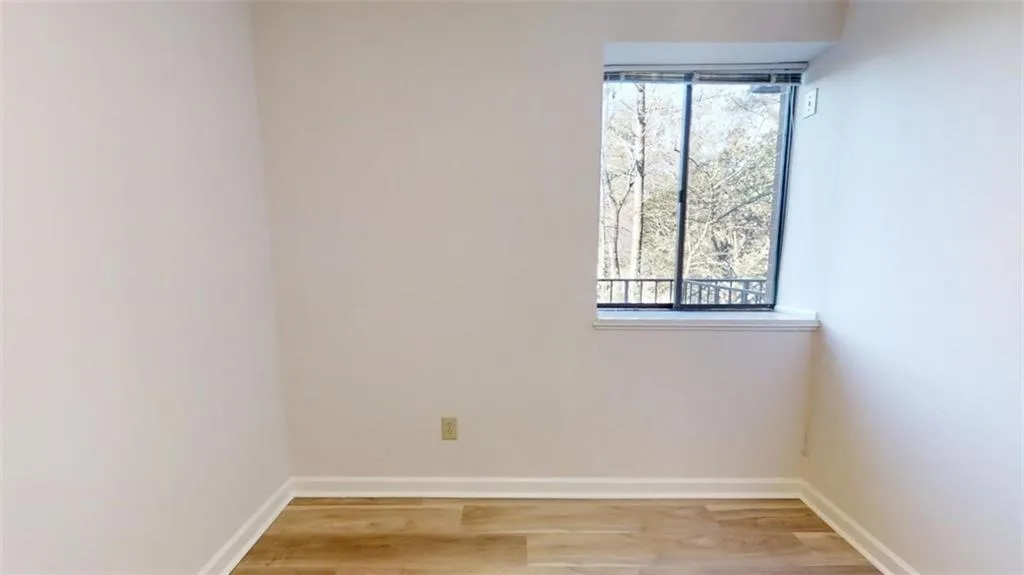 Spare room featuring light wood-style floors, baseboards, and a wealth of natural light