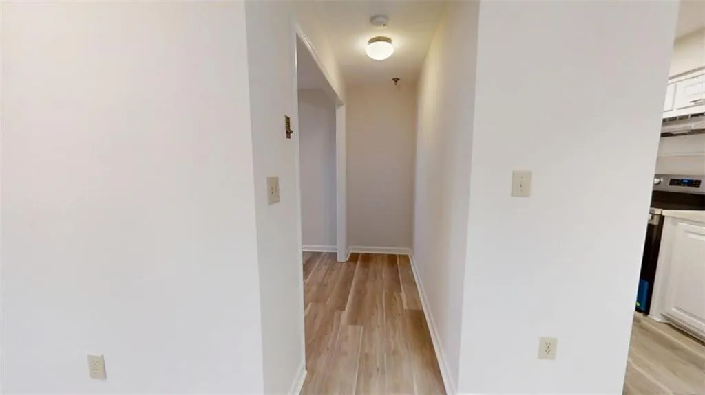 Hall featuring light wood-style flooring and baseboards
