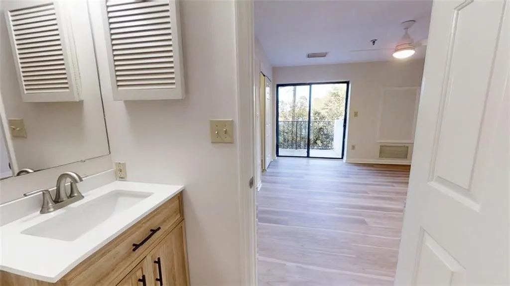 Bathroom featuring visible vents, vanity, baseboards, and wood finished floors