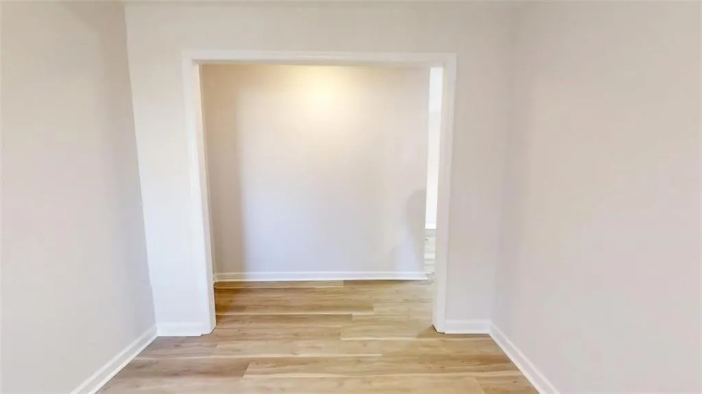 Corridor with light wood-style floors and baseboards