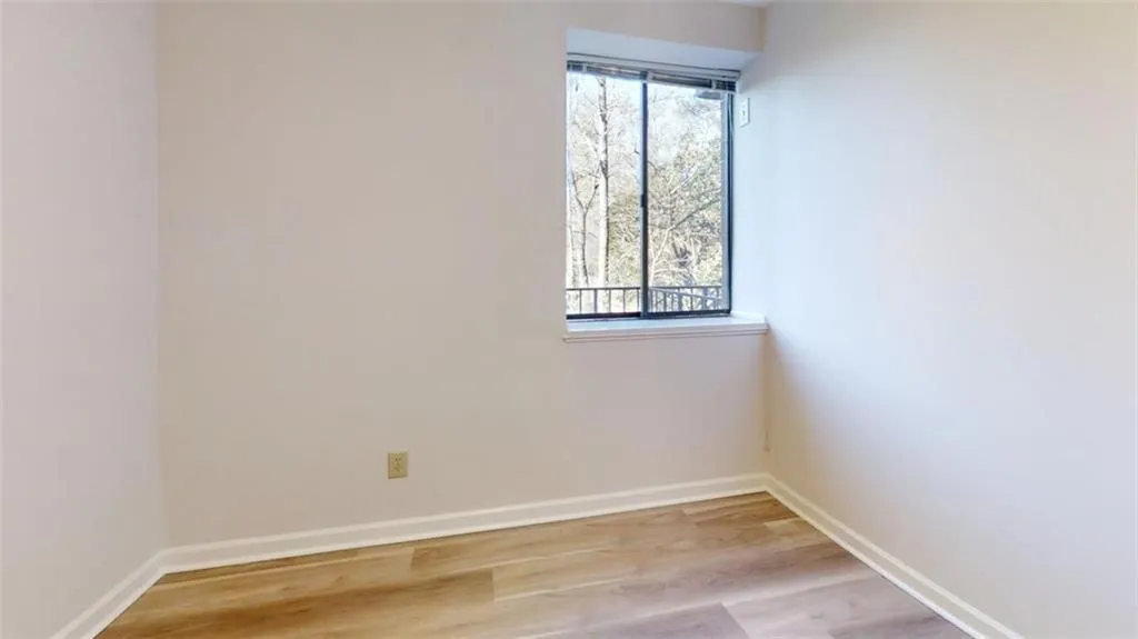 Spare room featuring light wood-style flooring and baseboards