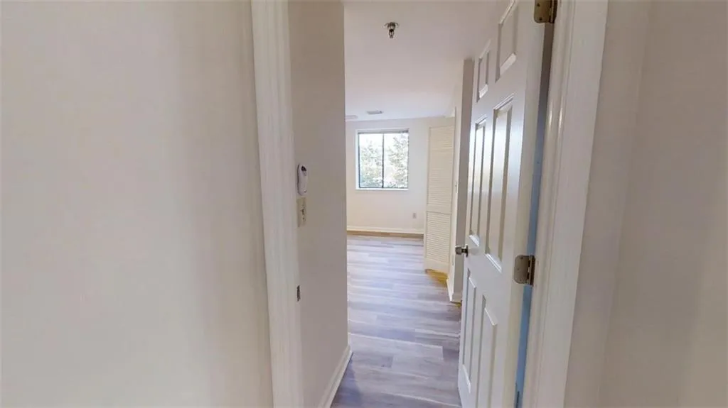 Hallway featuring wood finished floors and baseboards
