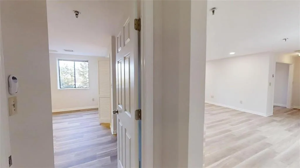 Hall with recessed lighting, light wood-style flooring, and baseboards