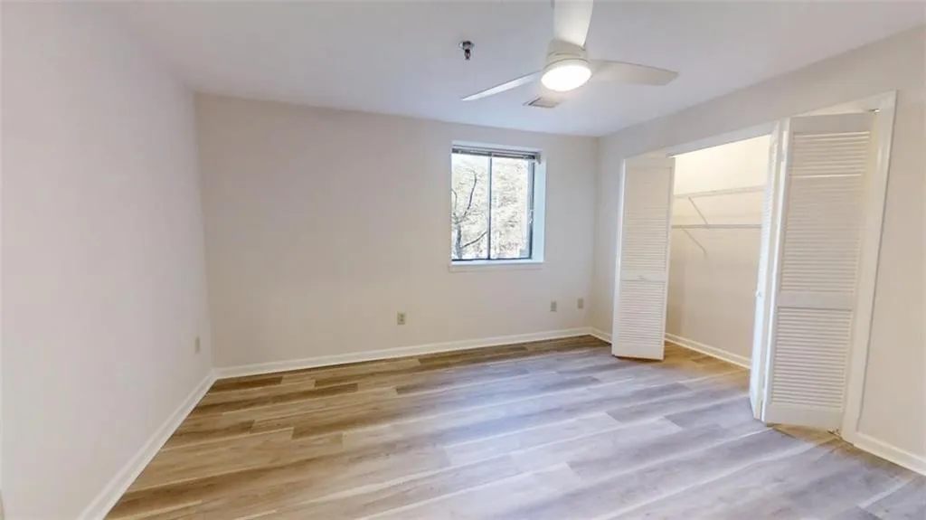 Unfurnished bedroom with light wood-type flooring, baseboards, visible vents, and a closet