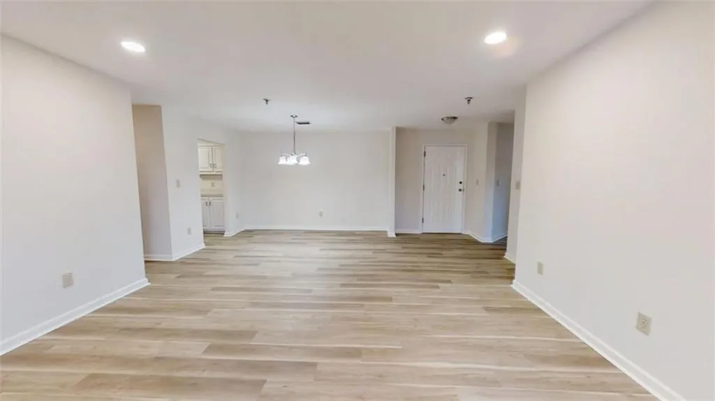 Spare room with light wood-style floors, baseboards, and recessed lighting