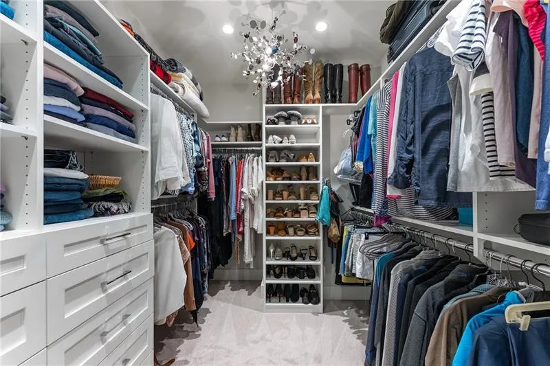Walk in closet featuring light colored carpet