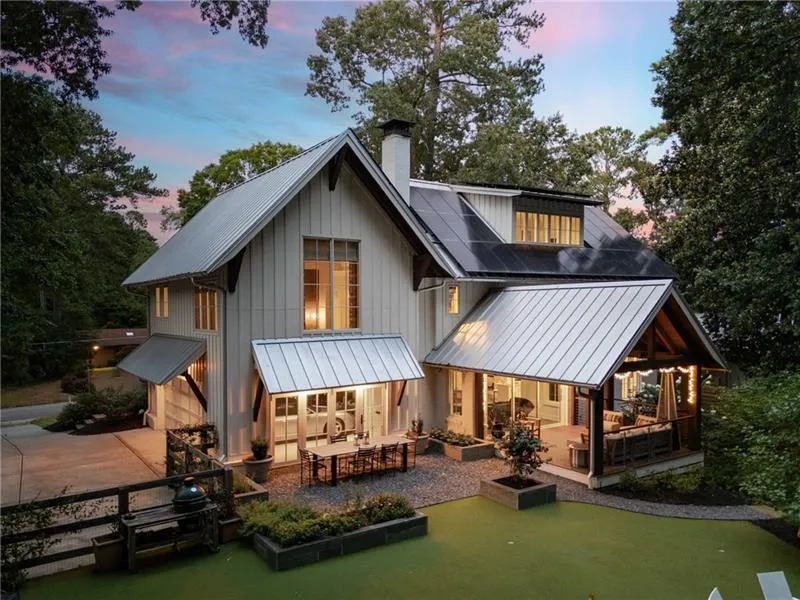 Napa-inspired Modern Farmhouse - back of house w/putting green, covered porch, and outdoor dining area.