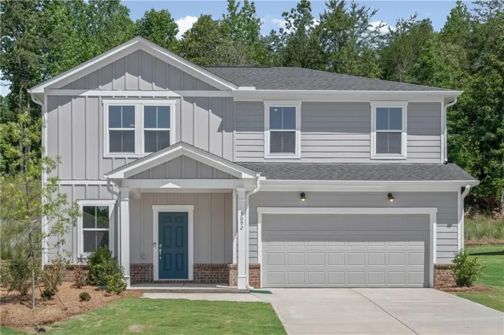 Two-story residence featuring light gray siding, white trim, and a dark teal front door