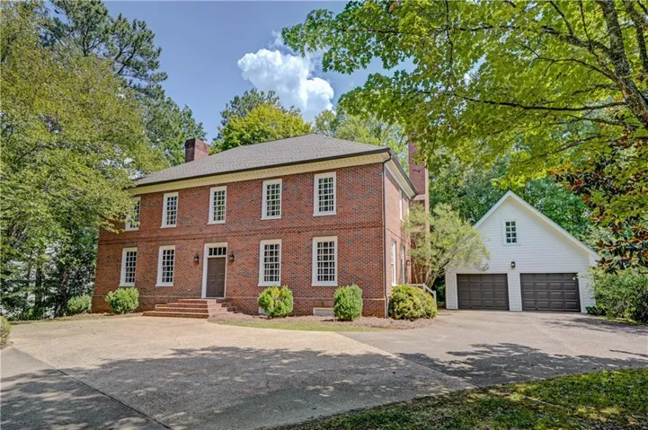 Developer of subdivision and original owner of Brick  Home with multiple windows, 2 prominent chimneys, and mature trees