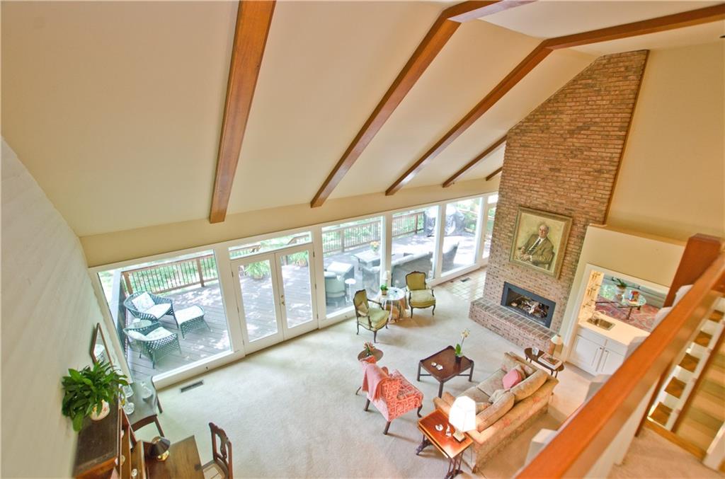 Vaulted living room with beamed ceiling and brick fireplace