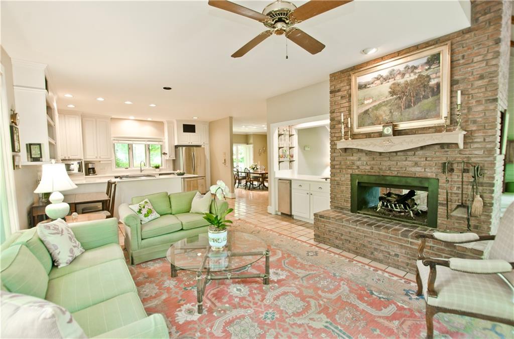 The cozy den opens to the kitchen and has a raised hearth brick fireplace