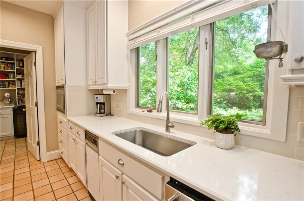 Kitchen featuring sink, white cabinets, and a healthy amount of sunlight