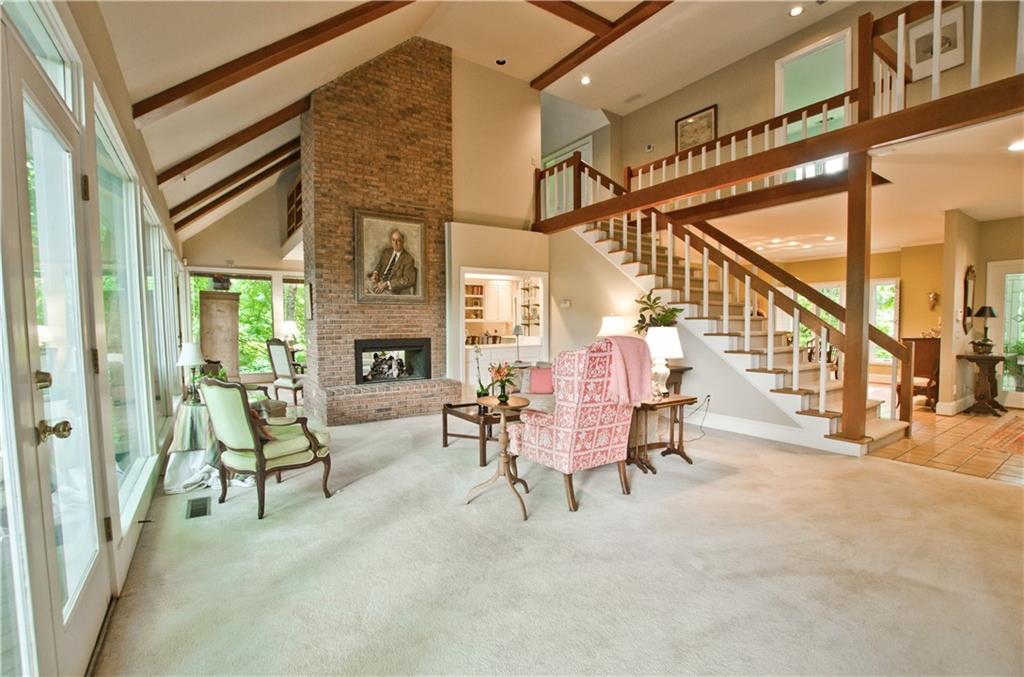 The living room has a vaulted and beamed ceiling and brick fireplace