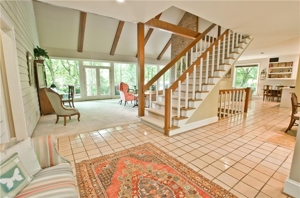 The open floor plan has a wall of glass and open staircase