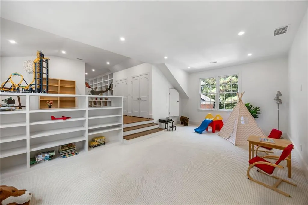 Recessed lighting, large windows, built-in shelving, white walls, and wood-finish stairs
