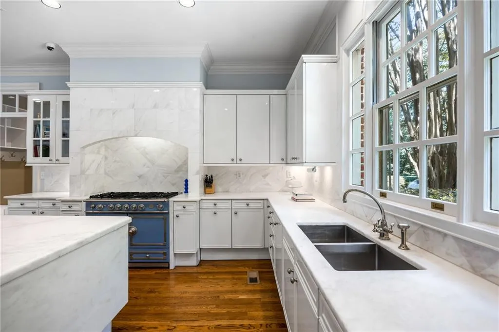 Kitchen featuring white cabinetry, stone countertops, a double basin sink, and a blue range with a matching stone backsplash