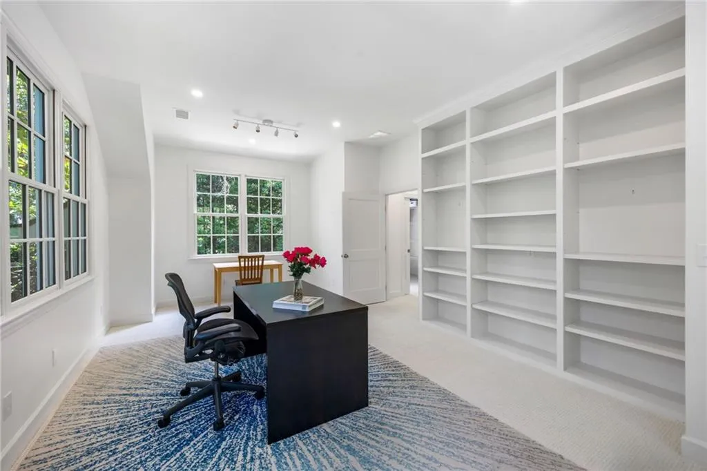 Recessed lighting, track lighting, built-in shelving, paneled door, and multiple windows