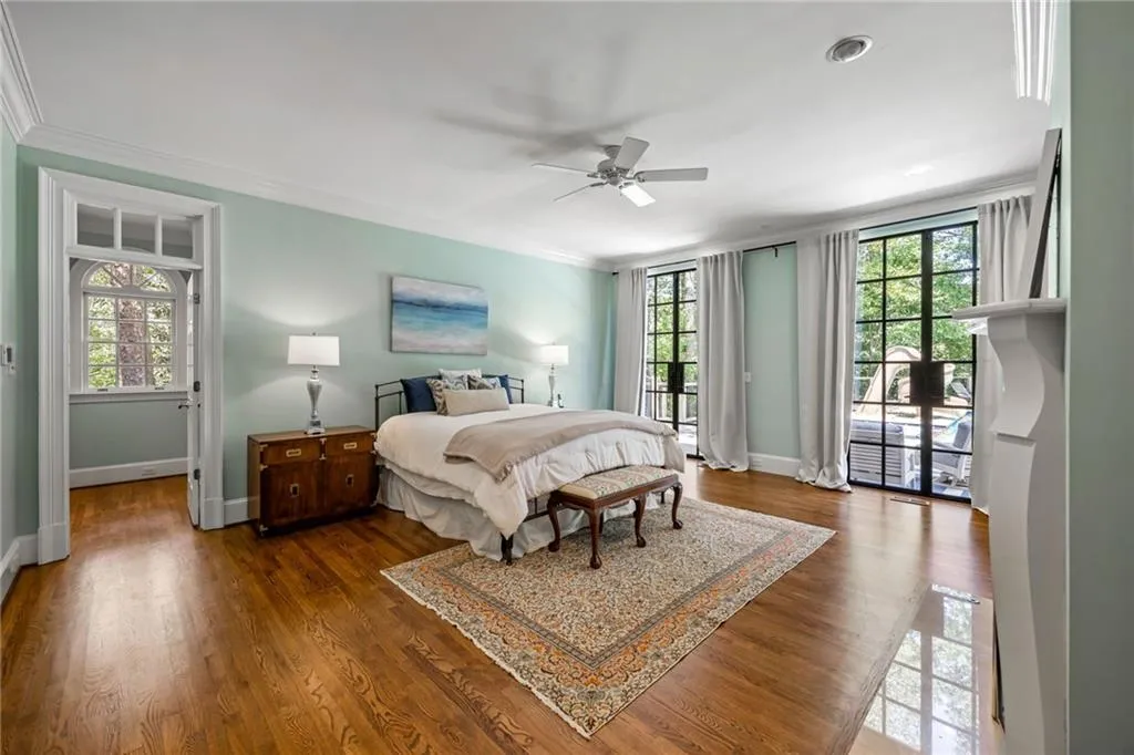 Hardwood flooring throughout, crown molding, double French doors, transom window, and a built-in fireplace mantel