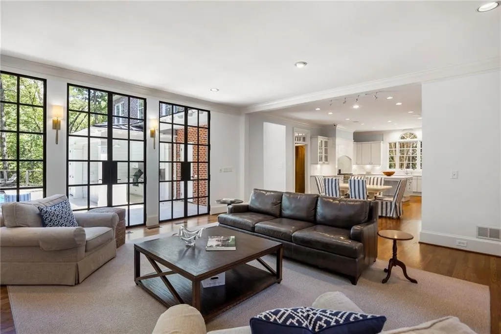 Hardwood flooring, recessed lighting, and crown molding define this versatile living area