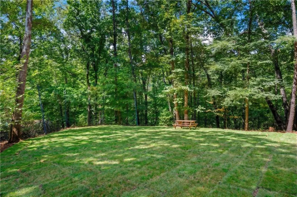 Expansive lawn area bordered by mature trees
