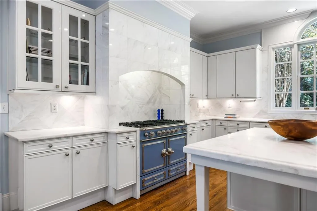 Gourmet kitchen with white cabinetry, stone countertops, a blue professional-grade range, and hardwood flooring