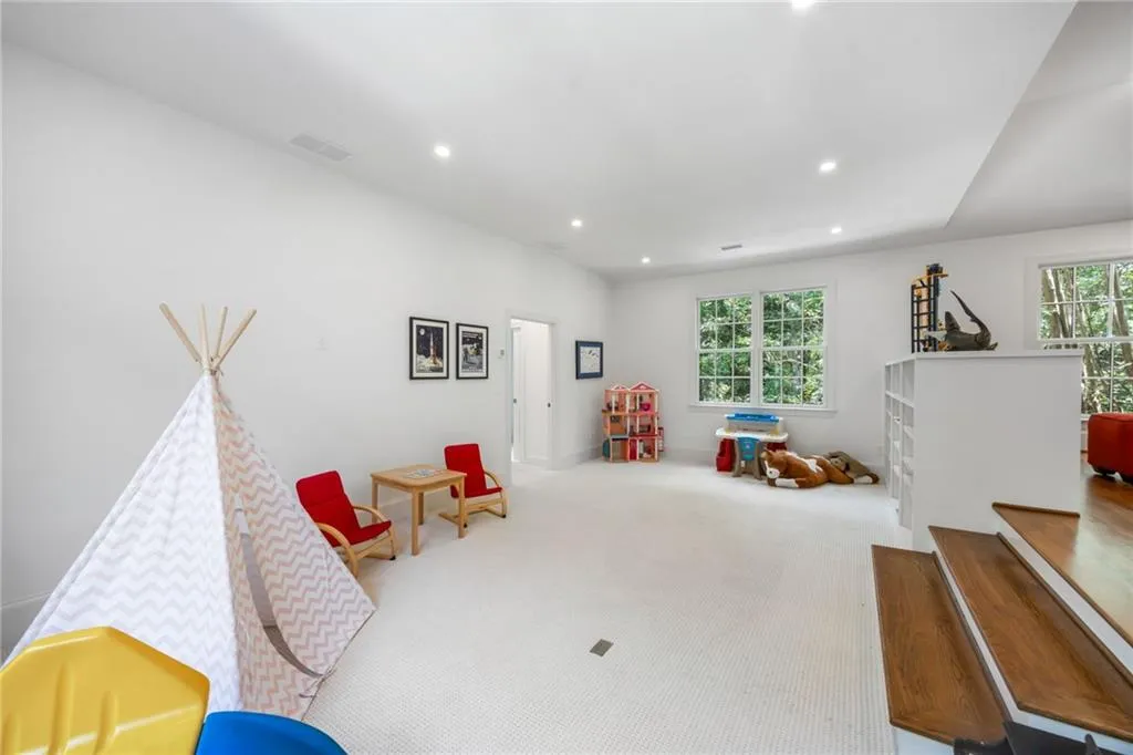 Spacious room featuring carpeting, recessed lighting, white walls, and multiple windows