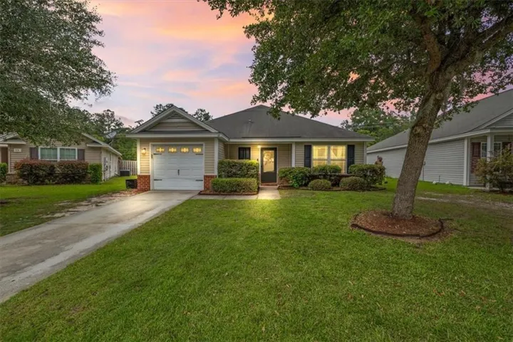 Single-story residence featuring light-colored siding, an attached garage, and a concrete driveway