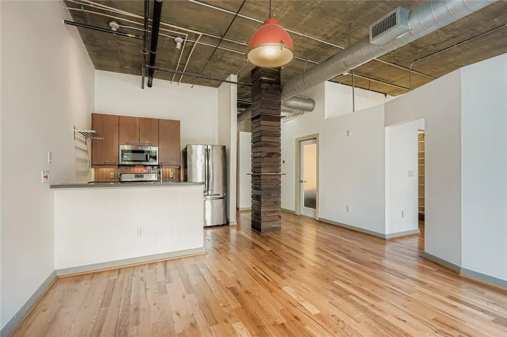 Unfurnished living room with a high ceiling and light wood-type flooring