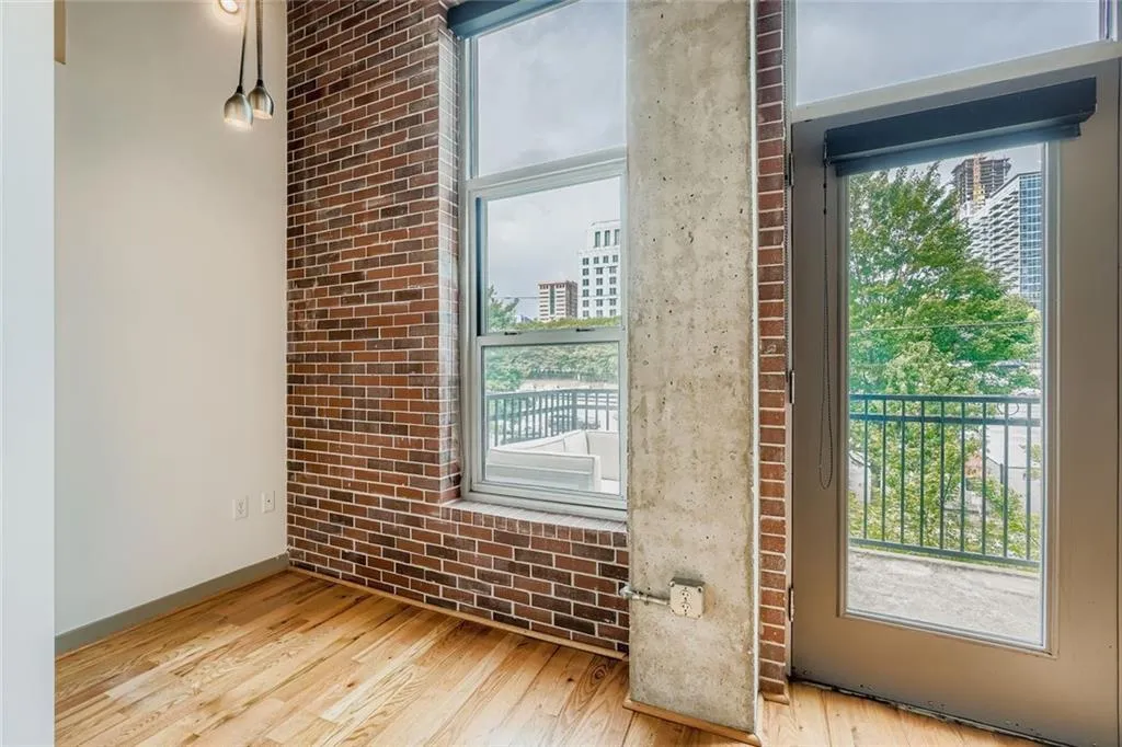 Entryway featuring brick wall, healthy amount of natural light, and wood finished floors