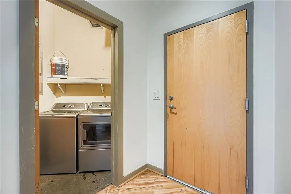 Laundry area with separate washer and dryer and light wood-style floors