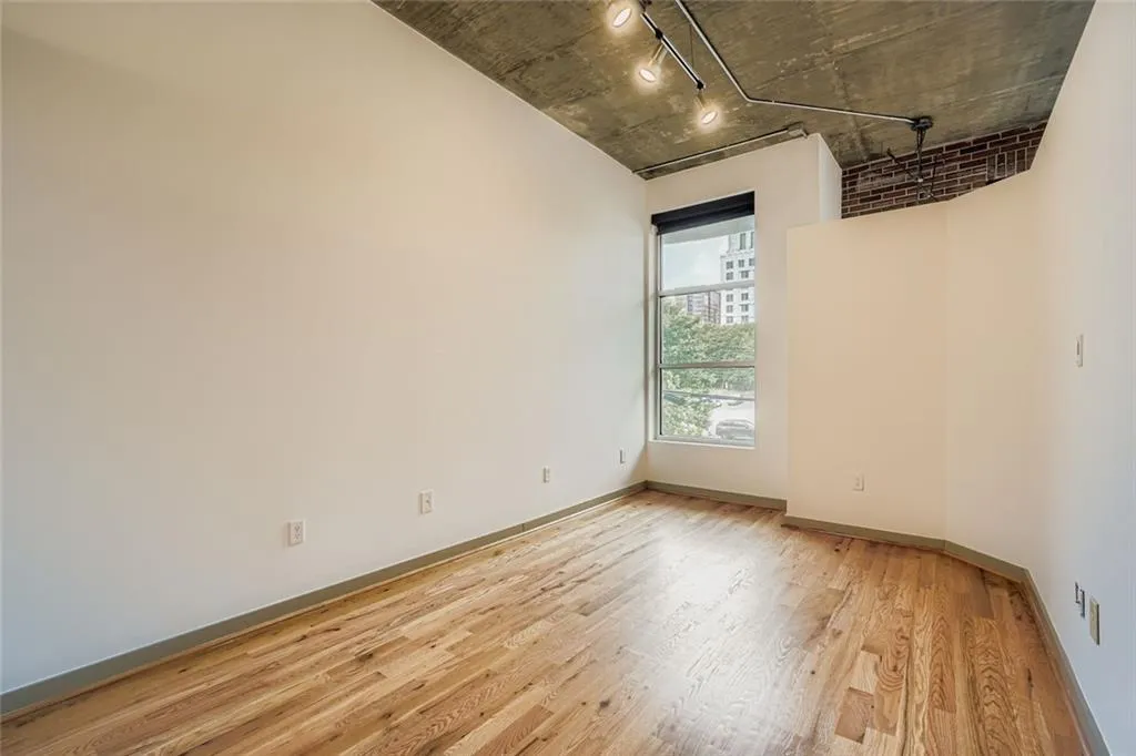 Empty room featuring track lighting and light wood-style flooring