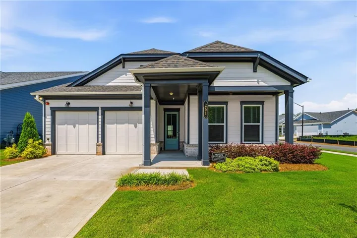 Contemporary exterior with light siding, dark trim, and a covered entry