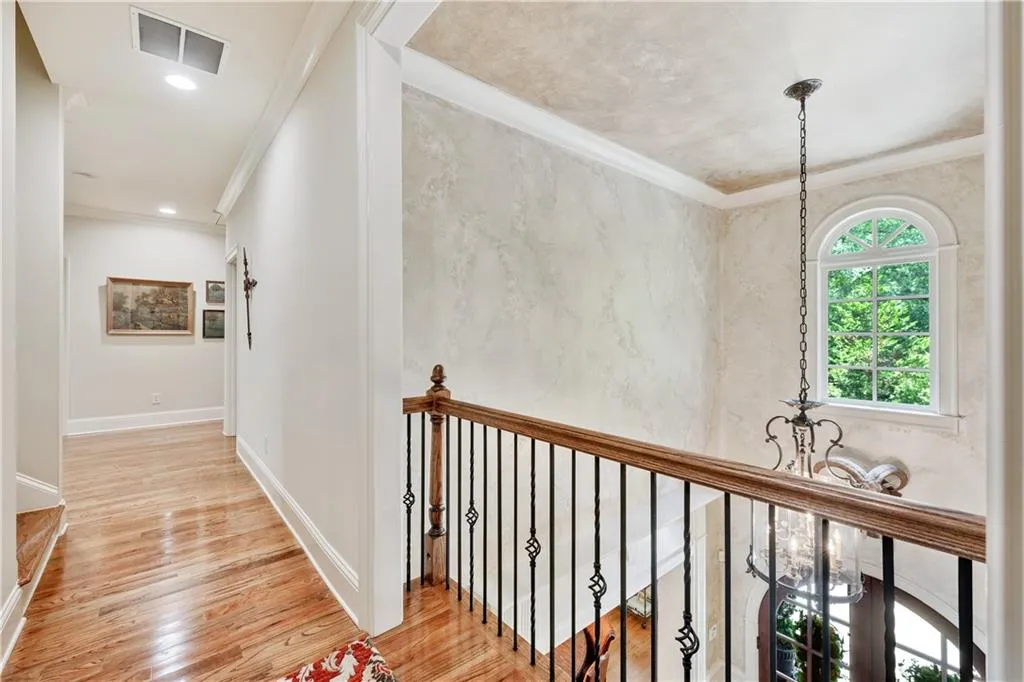 Hall with ornamental molding and light wood-type flooring