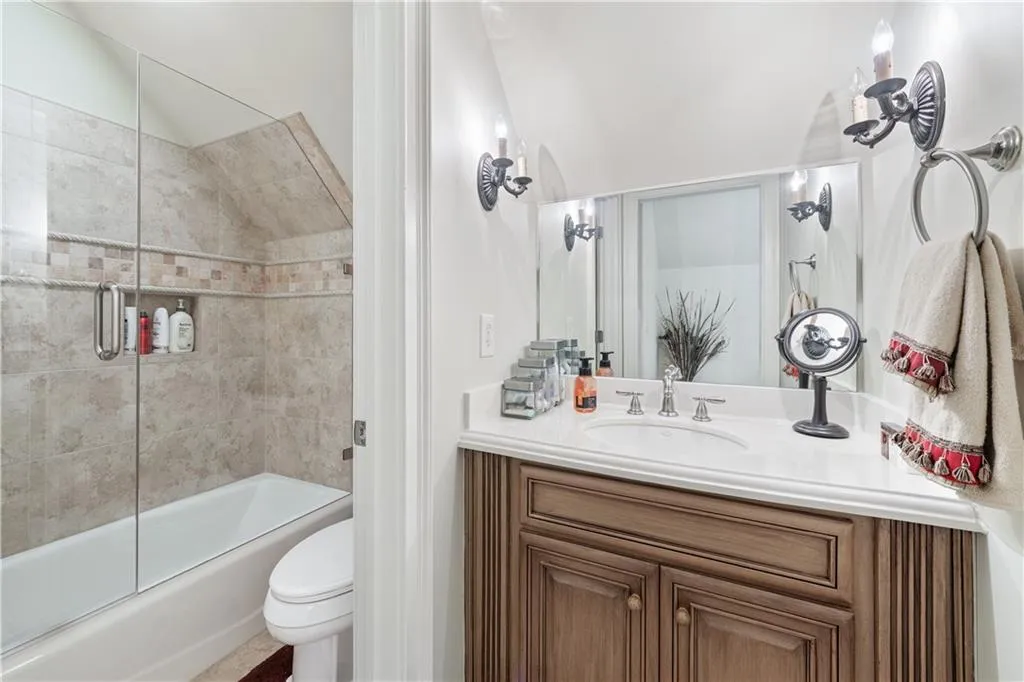Bathroom featuring vanity and shower / bath combination with glass door