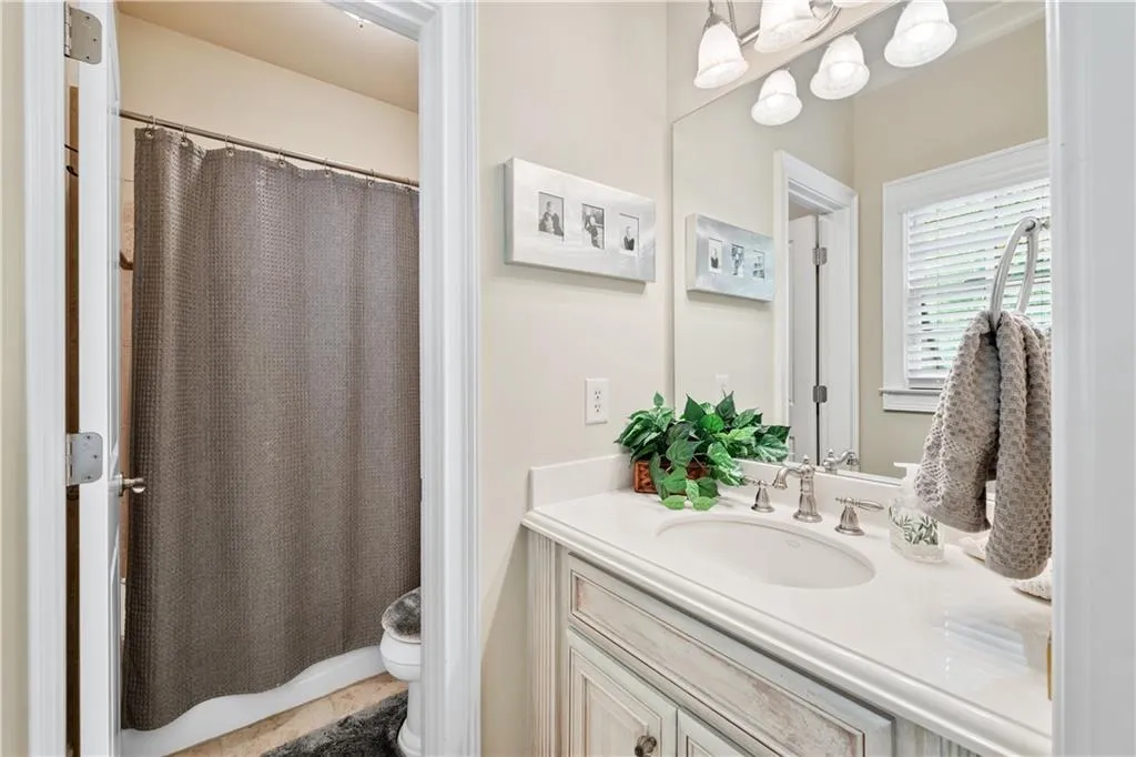 Full bath with vanity, curtained shower, and tile patterned floors