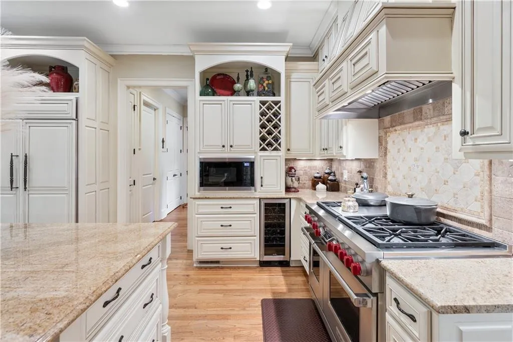 Kitchen featuring double oven range, open shelves, light wood-type flooring, wine cooler, and backsplash